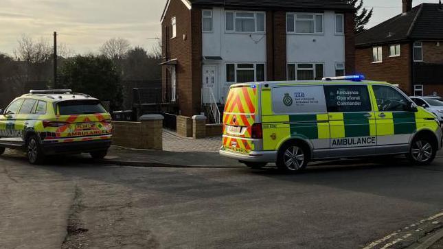 Two ambulance service vehicles outside a property in a residential street