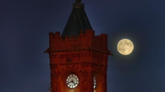 The supermoon can be seen behind the Pierhead Clock, famous Cardiff landmark.