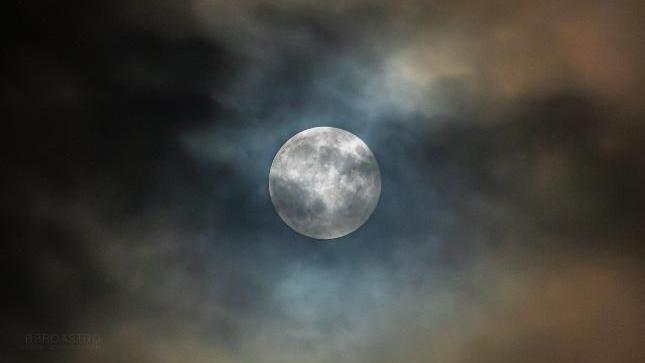 A large moon seen behind cloud