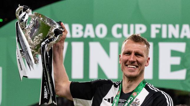 Newcastle's Dan Burn lifting the Carabao Cup trophy