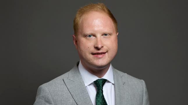 Mid Derbyshire MP Jonathan Davies. He has red hair and is wearing a green tie with a light grey suit.