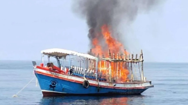 A small boat with a large fire seen on board 