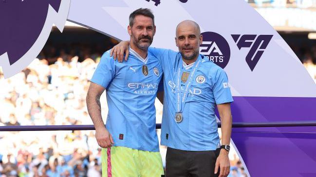 Scott Carson and Pep Guardiola after lifting the Premier League with Manchester City at the Etihad Stadium 
