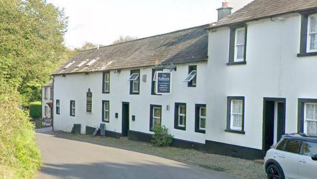 A Google Street View screenshot of the Kellbank hotel and restaurant in Gosforth. The building is on a small street and looking like a typical black and white Cumbrian cottage.