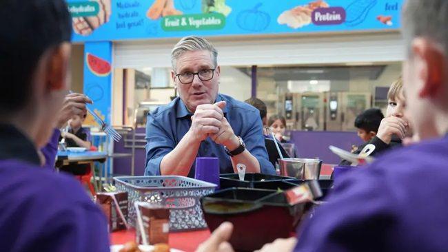Prime Minister Sir Keir Starmer helps serve lunch during a visit to Welland Academy, Peterborough, to talk about the importance of free school meals and tackling the cost of living.