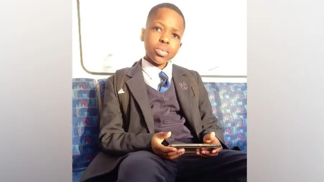 Daniel Anjorin pictured sitting on a bus wearing school uniform