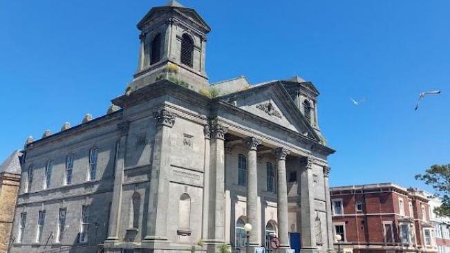 The front of Westborough Methodist Church showing the grey sandstone pillars at the entrance, with a clear, blue sky above. 