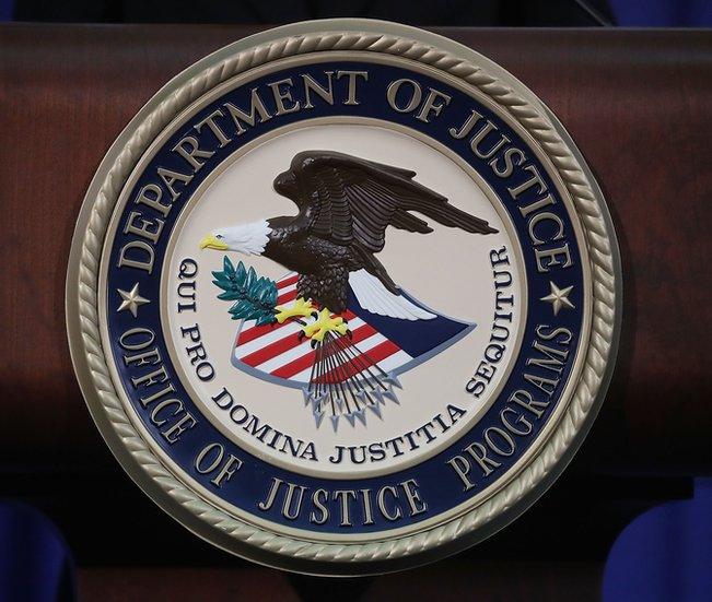 The US Department of Justice seal is seen on a lectern.