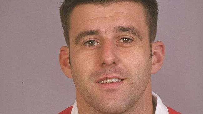 Matthew Back wearing Welsh rugby kit and looking directly at camera with neutral background