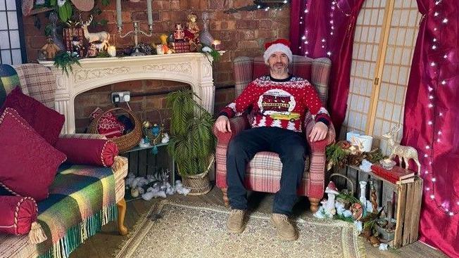 Phil Lyman sitting in a Santa's grotto