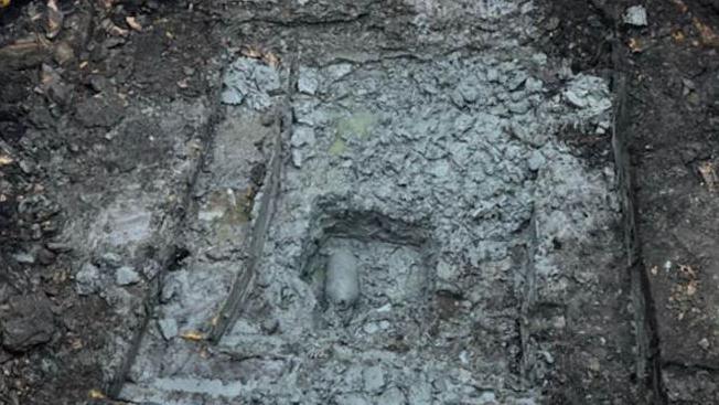 The WW2 bomb in the centre of the image. It is covered in concrete where it was found on a construction site. 