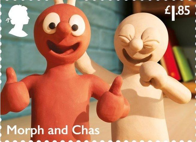 Animated characters from Morph, one is holding up bunny ears behind the other and laughing