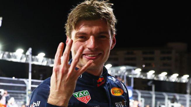 Max Verstappen holds his four fingers of his right hand up to the camera after winning the drivers' title at the Las Vegas Grand Prix