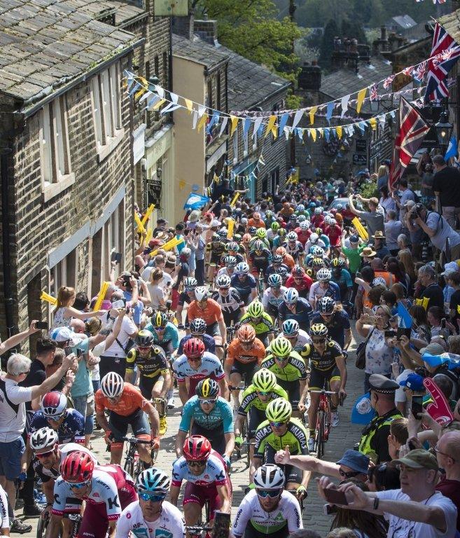 Cyclists ride through Haworth, Tour de Yorkshire 2018