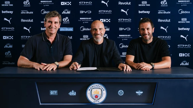 Enzo Maresca seen sitting at a desk with two other officials signing a contract.