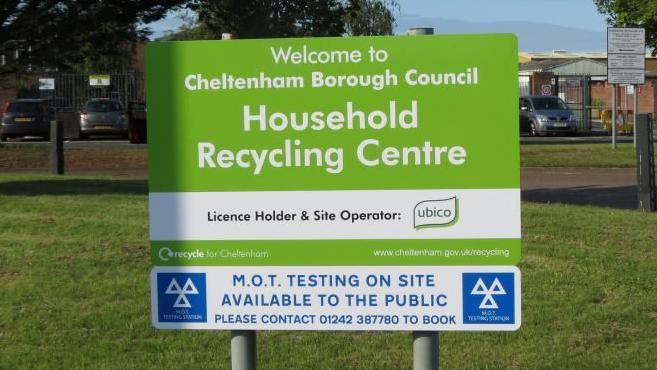 Signage at the Swindon Road household recycling centre in Cheltenham with an area of grass behind it