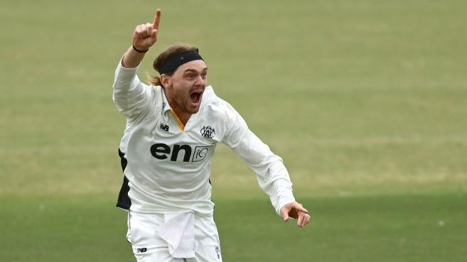 Corey Rocchiccioli screams with joy and points to the sky in celebration after taking a wicket for Western Australia