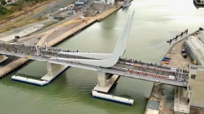 An aerial view of the Gull Wing Bridge in Lowestoft. People can be seen walking across it.