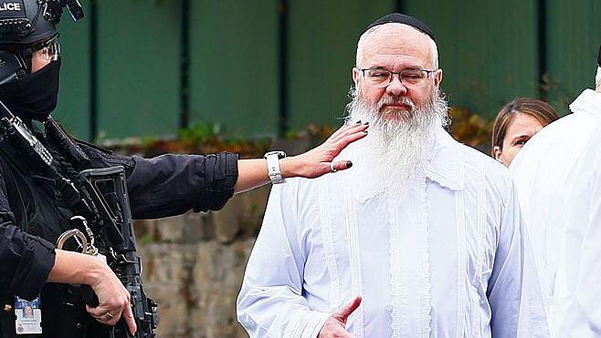 Rabbi David Walker outside the synagogue dressed in white robes.