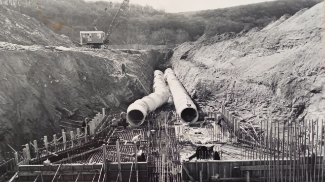 A black and white image showing construction under way of Trimpley Reservoir, showing the major pipes that sit beneath the surface, after huge excavations of earth have taken place