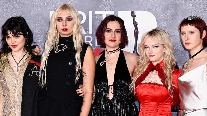 All five members of London indie band The Last Dinner Party posing for pictures on the red carpet