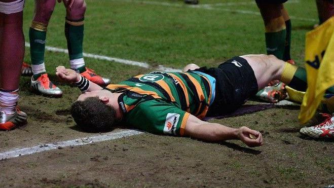 George North of Northampton Saints lays injured after colliding with Nathan Hughes of Wasps in