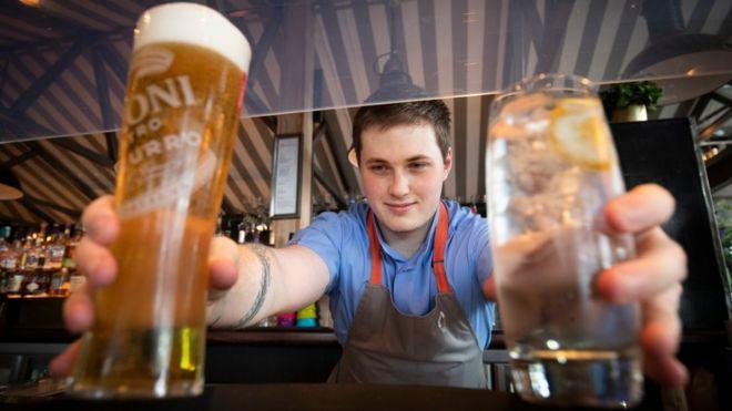 A barman serves drinks