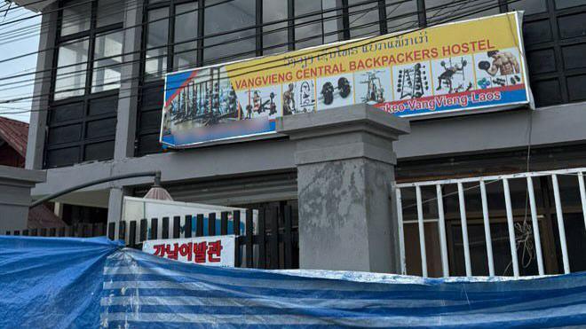 An image of the former Nana Backpacker Hostel in Laos under construction with a poster advertising it is reopening as the Vang Vieng Central Backpacker Hostel.