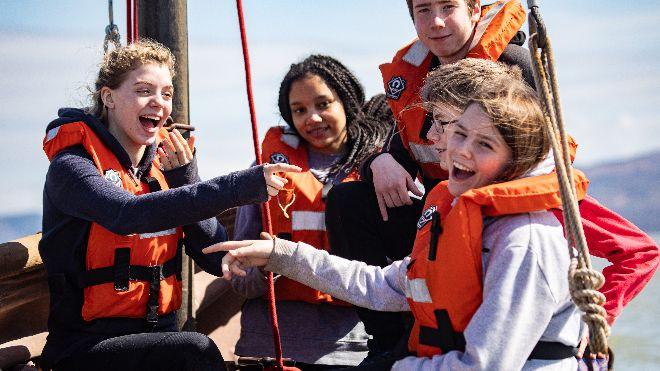 A modern-day picture of five participants sailing off Abverdovey in life jackets