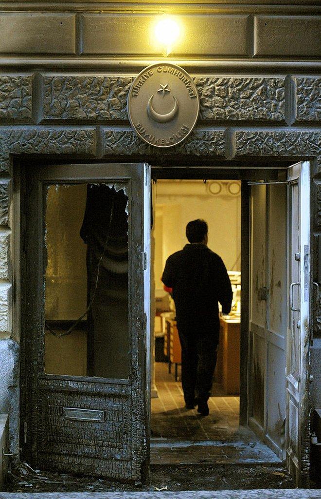 Finnish police inspect damage early on October 21, 2008 at the Turkish Embassy in Helsinki after the door of the embassy building was set ablaze around 3:00 am (0000 GMT), though the fire was quickly detected by a police patrol and extinguished. Finnish police have detained four men suspected of trying to set embassy on fire.