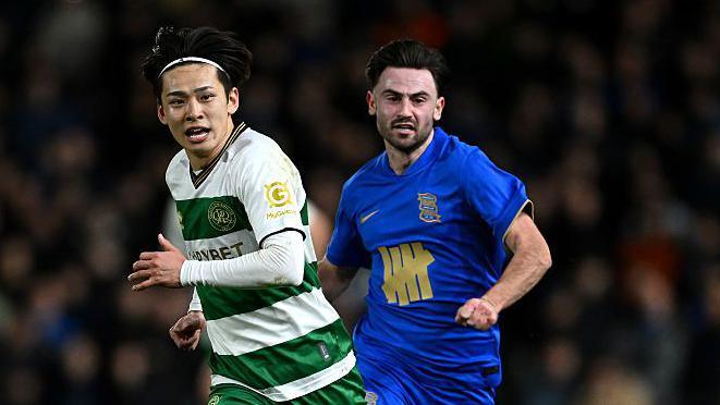 Koki Saito of Queens Park Rangers runs with the ball from Patrick Roberts of Birmingham City