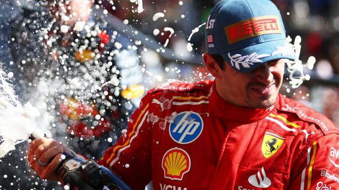 Charles Leclerc sprays champagne on the podium after winning the United States Grand Prix