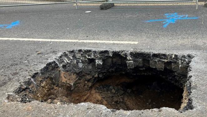 The large hole in Bury New Road which is barricaded off