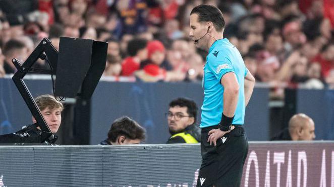 A referee goes to the VAR screen 