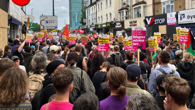 A large crowd of protesters gather in Walthamstow holding black lives matter and refugees welcome placards