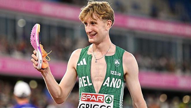 Nick Griggs holding the shoe that came off during Monday's 5000m final
