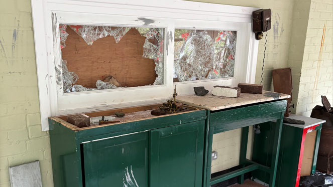 Smashed windows above a table inside a railway signal box