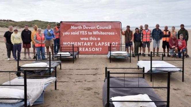 Campaigners on the beach with a big sign
