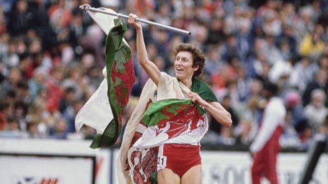 Kirsty Wade yn chwifio fflag genedlaethol Cymru ar ôl ennill ras 1500m yng Ngemau'r Gymanwlad 1986 i sicrhau'r fedal aur