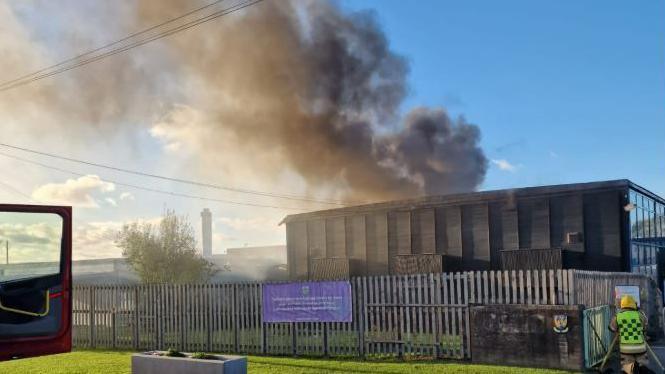 A view of the entrance to St Martins School, near Oswestry, with smoke plumes coming from the roof of the building
