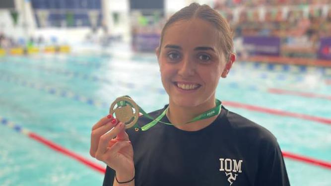 Laura Kinley holding her gold medal