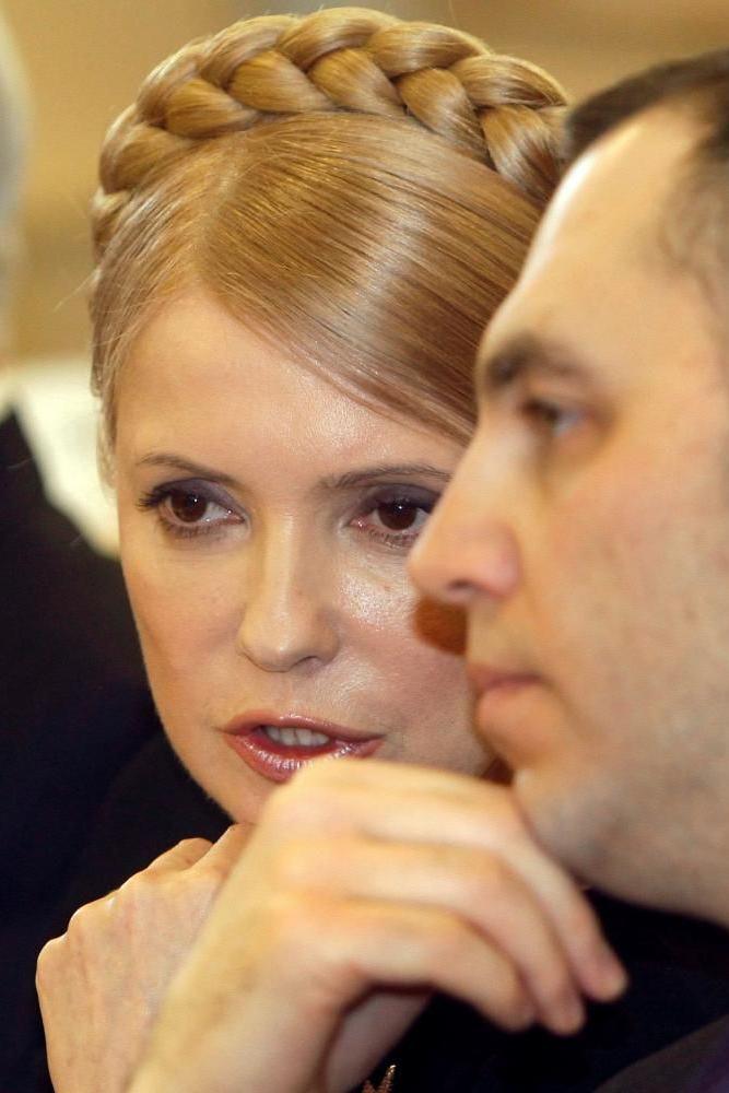 A file photo dated 19 February 2010 shows then Ukrainian Prime Minister Yulia Tymoshenko (a woman with blonde plaits on her head) speaking to her representative Andrey Portnov (a man with short dark hair) in Kyiv, Ukraine.