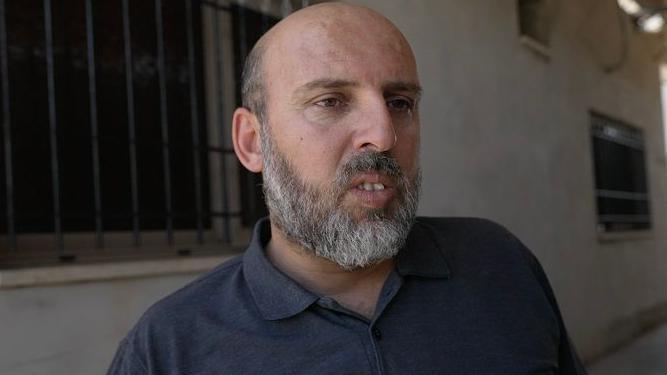 A middle-aged Palestinian man with balding hair and a short beard.