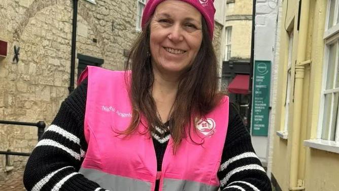 Chrissie Lowery smiling while wearing a pink hi vis vest