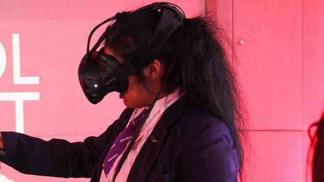 School girl in purple school uniform with long black hair wearing virtual reality equipment 