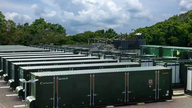 Image shows a battery energy storage site with rows of green containers 