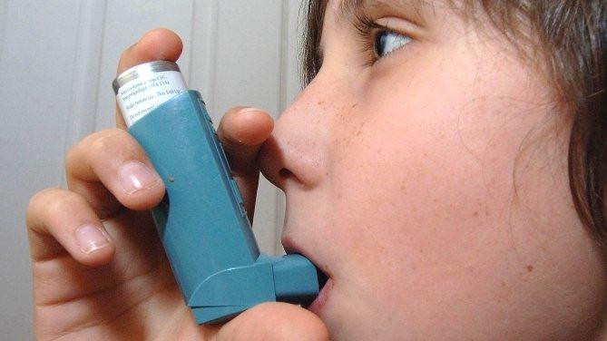 A boy using an asthma inhaler