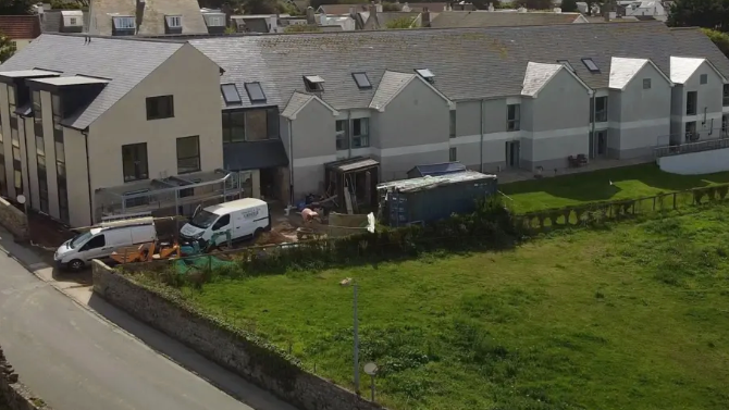 A two-storey block with new two-storey units and what appears to be construction work going on.