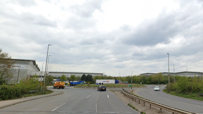 A view of the roundabout near the white Amazon building - with street lights on either side