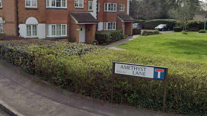 A sign saying Amethyst Lane on a residential road. 